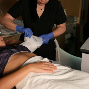 Person receiving a laser treatment on their back in a clinical setting.