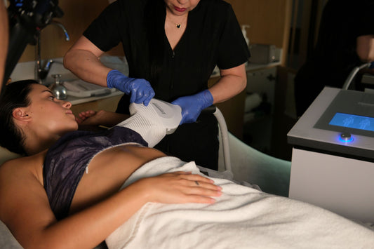 Person receiving a laser treatment on their back in a clinical setting.